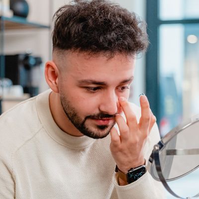 A man trying to put in a contact lens.